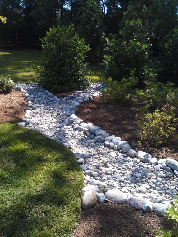 charlotte-french-drain Construction of a curved brick pathway in Charlotte, showcasing expert hardscaping techniques.